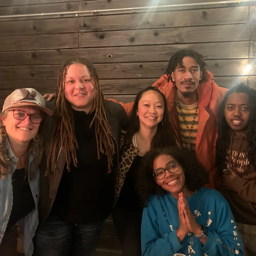 six smiling people grouped together