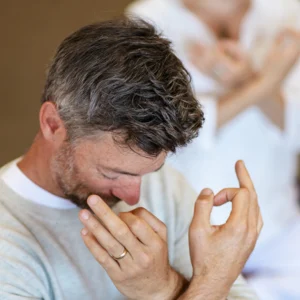 Person performing hand mudras with head bowed for Mount Madonna's New Year's Yoga Retreat in Northern California