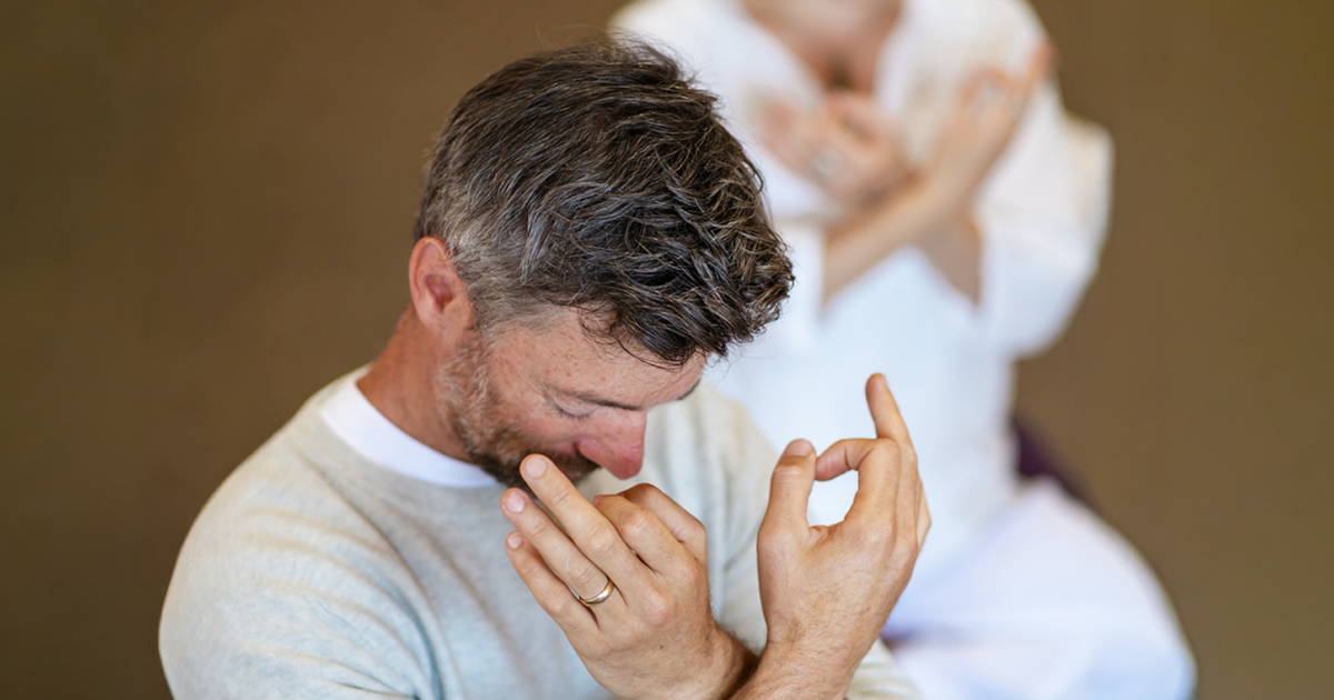 Person performing hand mudras with head bowed for Mount Madonna's New Year's Yoga Retreat in Northern California