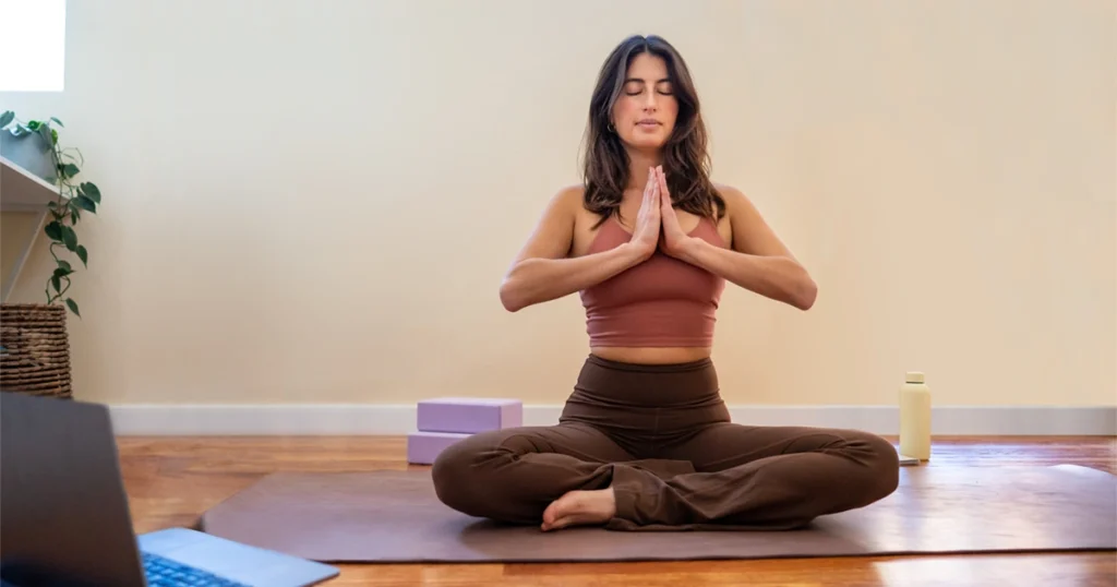 Yoga Teacher Training YTT 200 student meditating while taking online course