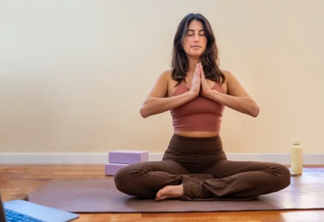 Yoga Teacher Training YTT 200 student meditating while taking online course