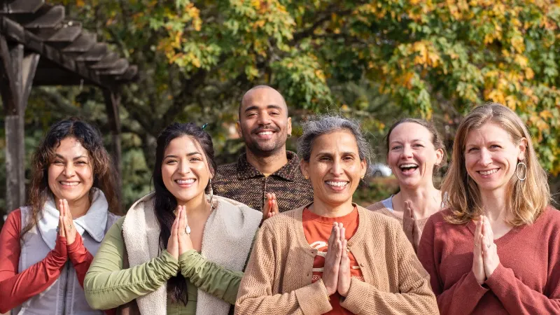 rotational volunteers smiling in namaste at Mount Madonna