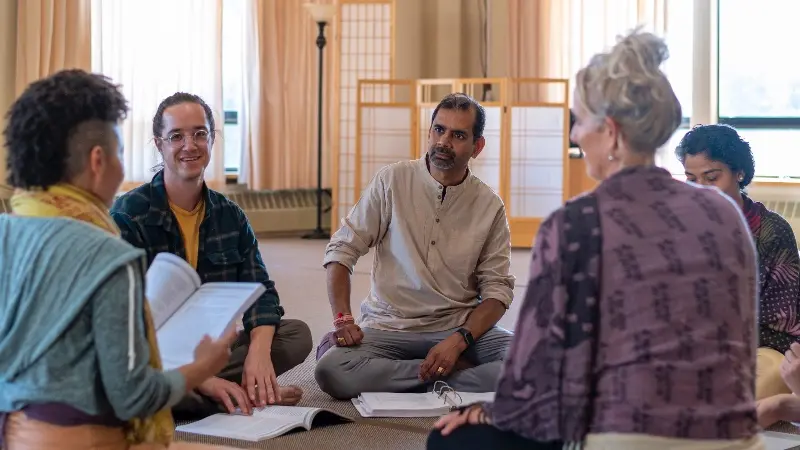 Yoga Teacher Training students in small group discussion reflecting on their personal motivations