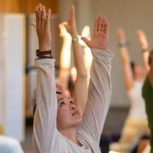 People with arms stretched upward in all-levels yoga class