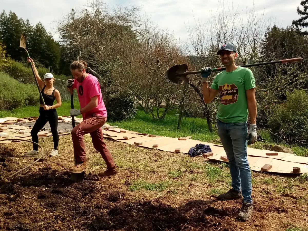Rotational volunteers, Brenna, Dan, and Michael G., shovel soil in the garden while serving during the Volunteer Program at Mount Madonna.