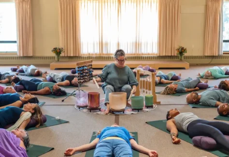 People in restorative yoga class experiencing sound immersion with crystal singing bowls