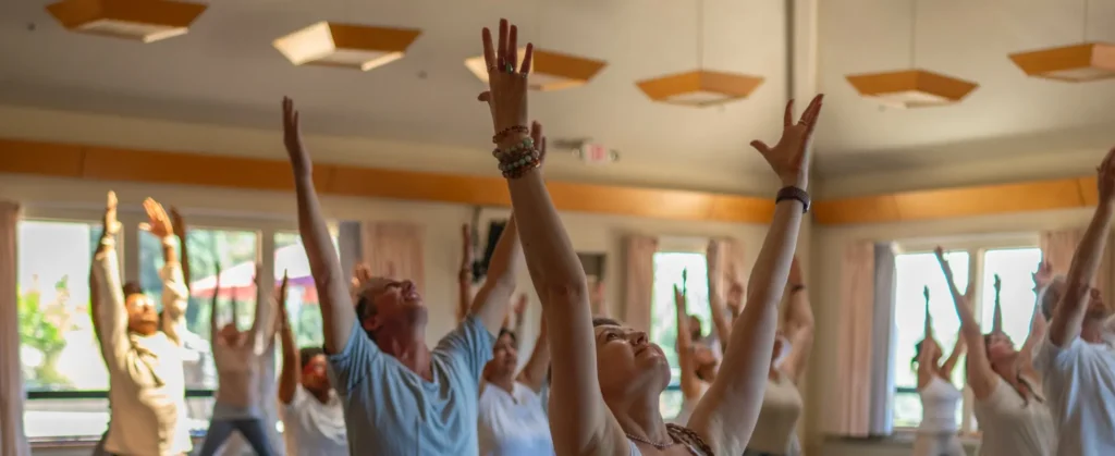 A room at Mount Madonna Center with Yoga Teacher Training YTT 300 Program students practicing indoors in the Santa Cruz Mountains.