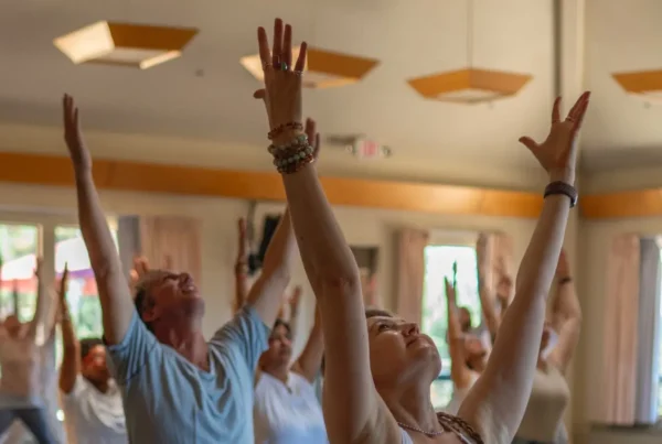 A room at Mount Madonna Center with Yoga Teacher Training YTT 300 Program students practicing indoors in the Santa Cruz Mountains.