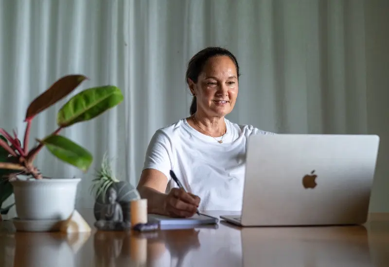 Yoga teacher at a desk reviewing credentials and professional teaching materials