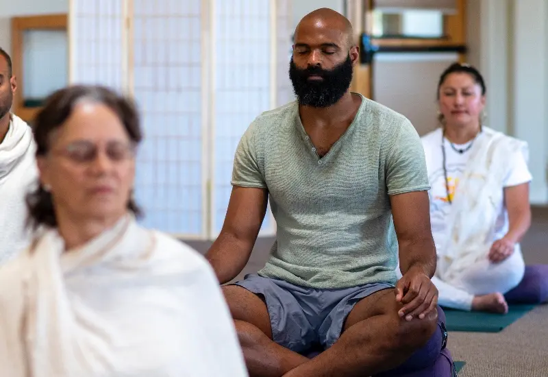 Yoga students seated in meditation during a Mount Madonna teacher training, reflecting on intention and personal practice