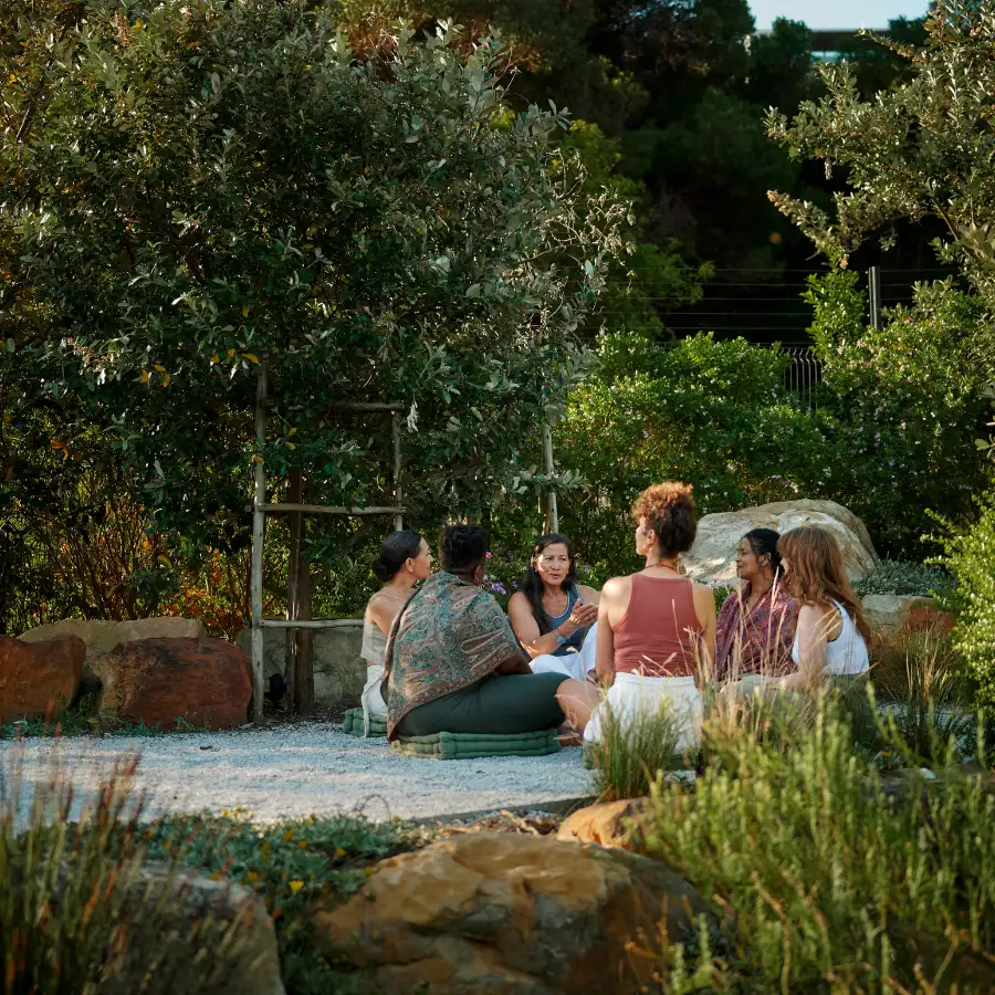 Circle of people in a garden for The Rooted Return retreat