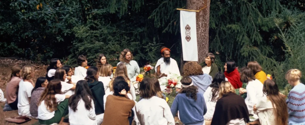 Group of people sitting with Baba Hari Dass in the forest