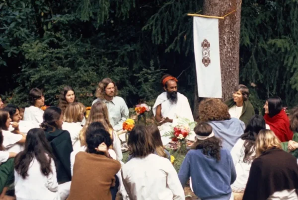 Group of people sitting with Baba Hari Dass in the forest