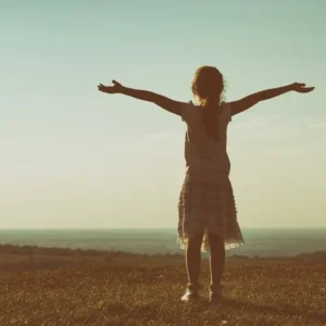 Child facing the ocean with arms outstretched for Alison Harre's inner child healing retreat Coming Home to Joy.