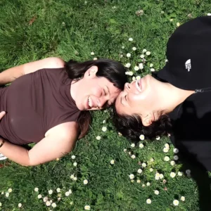 Lily Manderville and Vrinda Priti laying on the grass for their fall retreat "Re:member - A Weekend Retreat to Reveal Our Joyful Nature."