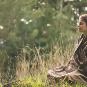 Person sitting outside in meditation at Mount Madonna, a yoga retreat center in Northern California