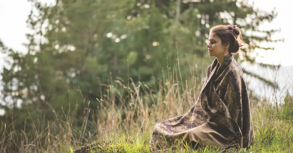 Person sitting outside in meditation at Mount Madonna, a yoga retreat center in Northern California