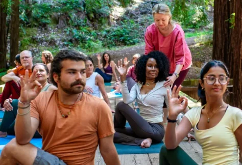 People in yoga asana (postures) class on a bridge in the forest during Mount Madonna's Foundational Yoga Studies In-Person YTT 200 Intensive