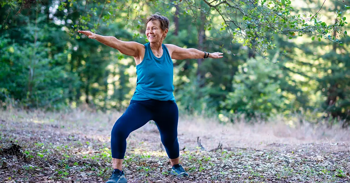 Person outside in warrior 2 pose for online Hatha Yoga class